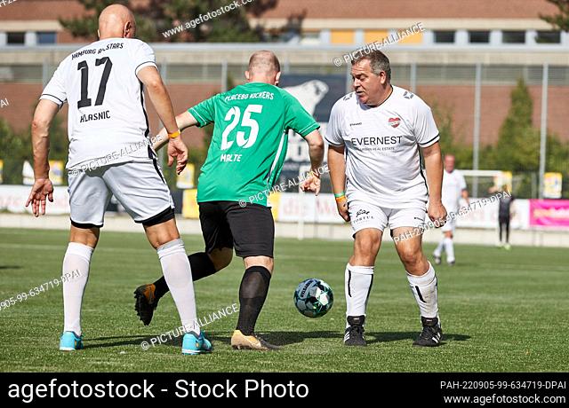 04 September 2022, Hamburg: Elton (r), TV presenter, plays for the ball at the ""Kicken mit Herz"" charity event. Under the motto ""Soccer Peace & Love - Flower...