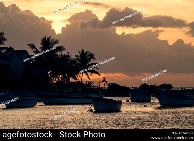 A small bay in Mauritius with several anchored boats at dusk