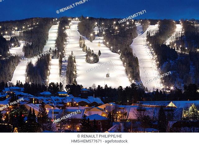 Canada, Quebec province, Laurentians region, St Sauveur, the city and in the background the ski slopes lit at night