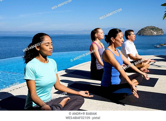 Yoga group exercising at ocean front resort