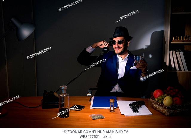 Detective sitting in dark room in vintage concept