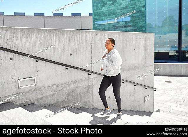 african american woman running upstairs outdoors