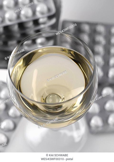 Glass of wine and pills in blister pack, close-up