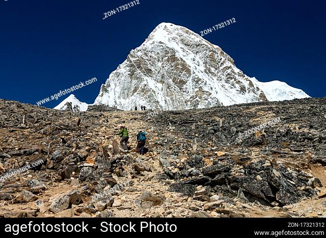 Trekkers climbing Kala Patthar peak (c. 5640m) above Gorakshep in the Khumbu Valley. Pumori (7161m) is above them. Everest Base Camp Trek