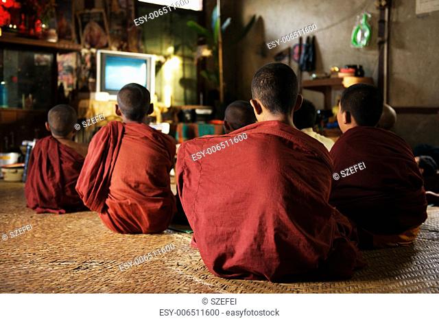 Group of Southeast Asian young little Buddhist monks enjoying tv show, Inle, Myanmar