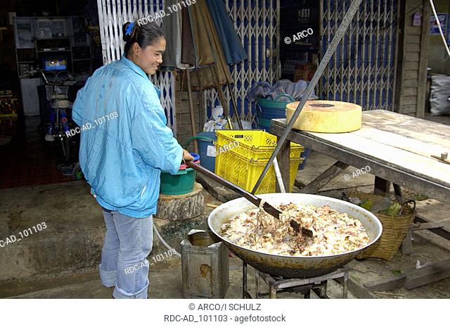 Thai woman deep-frieing pigskin Pat Chong Market Thailand Thai-Frau frittiert Schweinehaut Pat Chong Markt Thailand kochen cooking
