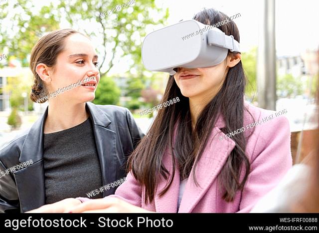 Businesswoman looking at colleague using virtual reality headset