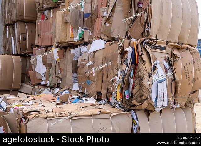 Bales of cardboard and box board with strapping wire ties. Background of paper textures piled ready to recycle