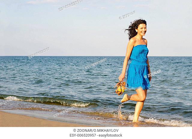 Woman running along the edge of the surf