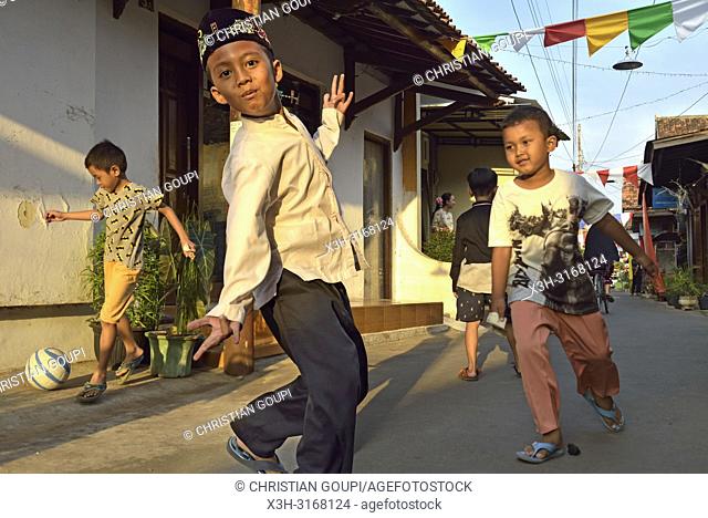 young boys playing ball in a street of Kauman Batik Village (Kampung) that is a district, with many Batik producer and craftmen, of Pekalongan, Java island