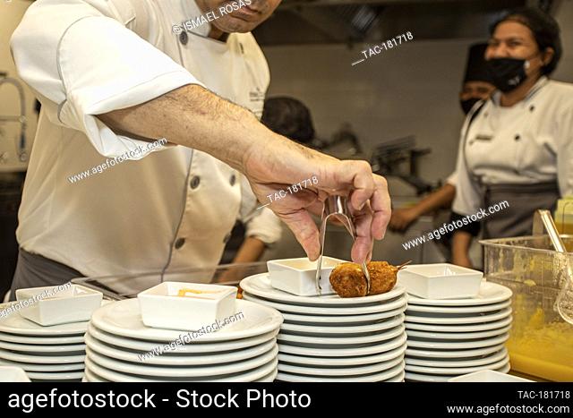 CANCUN, MEXICO - OCTOBER 10: Chef David Nunez prepares a dish food takes safety measures during the inauguration of the Brazilian restaurant 'Divina Carne' amid...