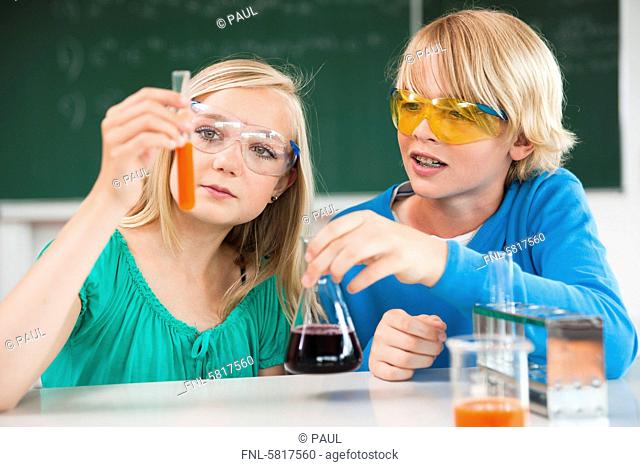 Schoolboy and schoolgirl experimenting in chemical class