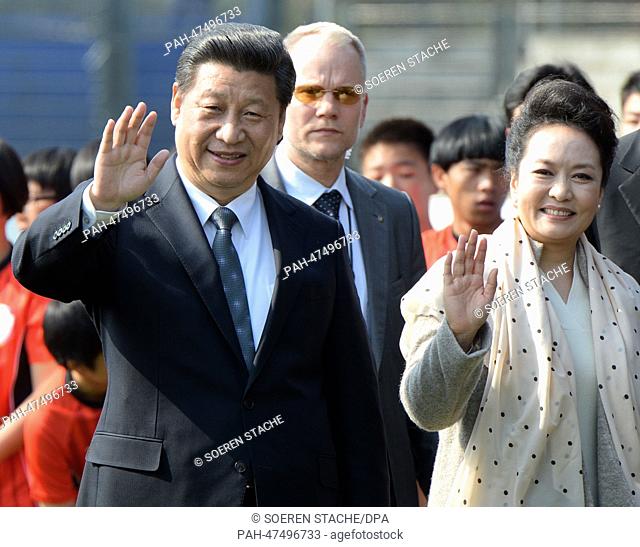 Chinese President and General Secretary of the Communist Party of China, Xi Jinping, and his wife Peng Liyuan say goodbye during a friendly soccer match between...