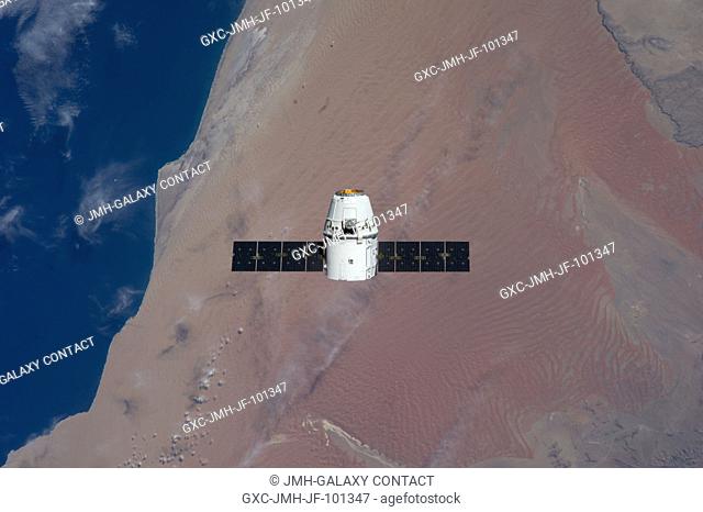 Backdropped against the Namib Desert on the Atlantic coast of Namibia, the SpaceX Dragon commercial cargo craft approaches the International Space Station on...