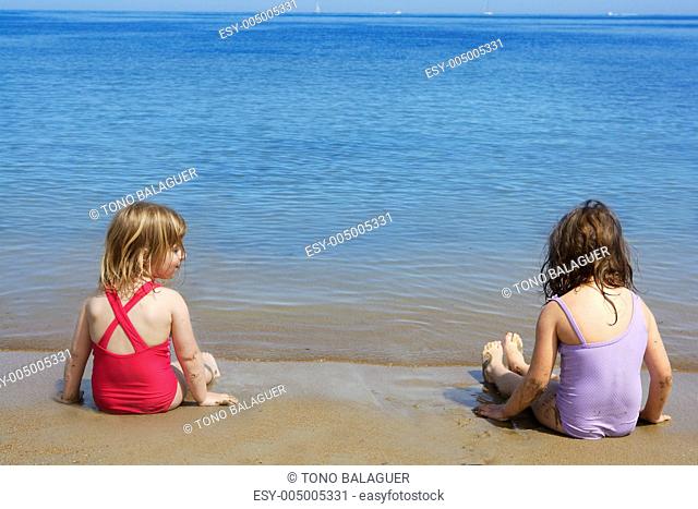 tow sisters sit on beach bathing suit swimsuit