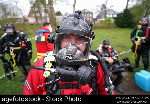 30 March 2022, Hamburg: Divers from the German Life Saving Association (DLRG). (DLRG) sit on a park bench on the banks of the Alster and wait for their trash...