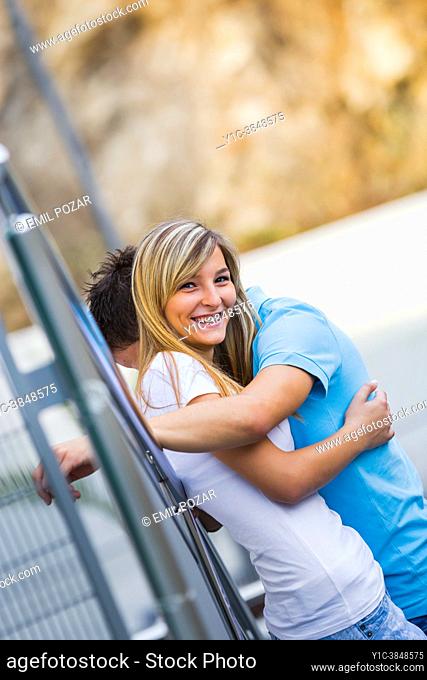 Adolescent teen couple embracing together happy
