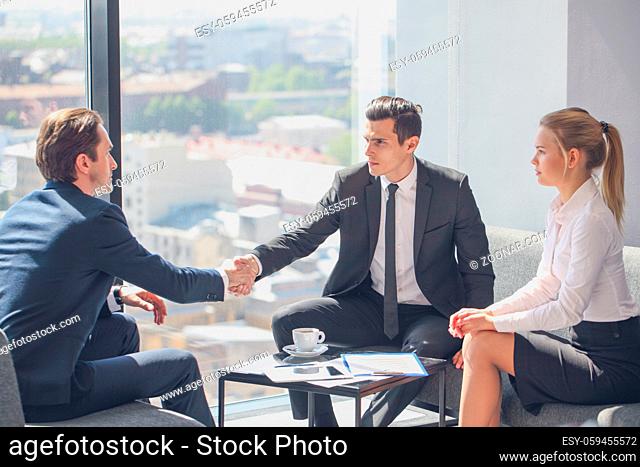 Interviewer shaking hand of an interviewee during a job interview in office