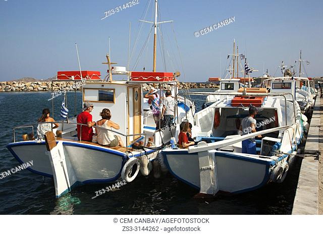 Tourists going on a daily boat trip with traditional boats in Naoussa port, Paros Island, Cyclades Islands, Greek Islands, Greece, Europe