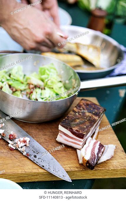 Fried zander with pointed cabbage and bacon being made