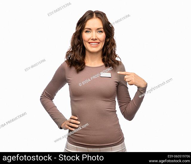happy female shop assistant showing her name tag