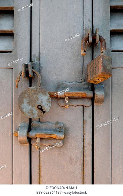 rusty old padlocks and locking bolts on metal doors
