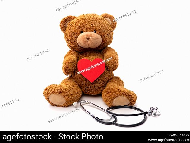 teddy bear toy with stethoscope holding red heart