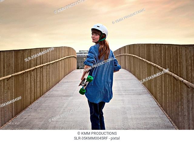 Girl riding skateboard on walkway