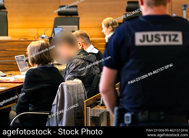 06 October 2023, Baden-Württemberg, Freiburg: The defendant (2nd from left) sits between an interpreter and his defense attorney