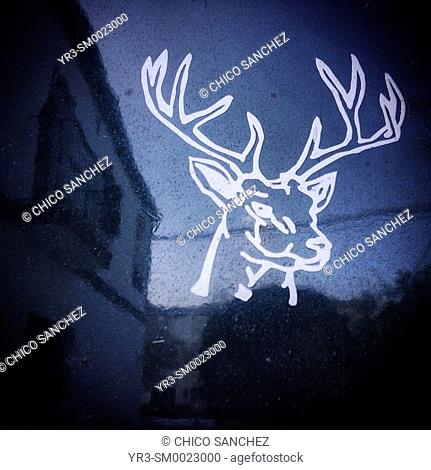 A sticker of a deer decorates a window in Prado del Rey, Sierra de Cadiz, Spain