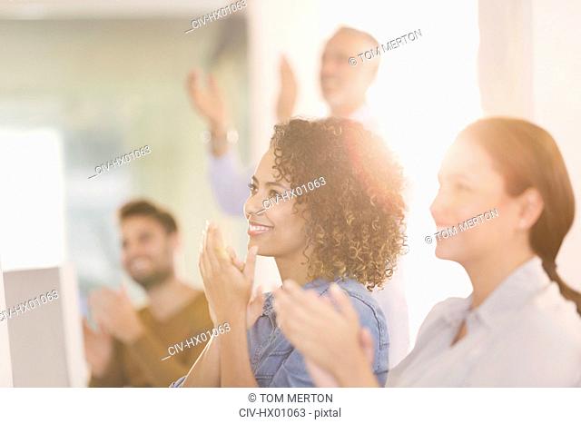 Businesswomen clapping in office