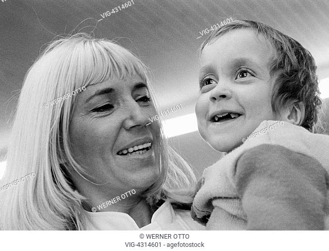 DEUTSCHLAND, OBERHAUSEN, STERKRADE, 27.02.1975, Seventies, black and white photo, people, physical handicap, fostress carries a handicapped girl on her arms