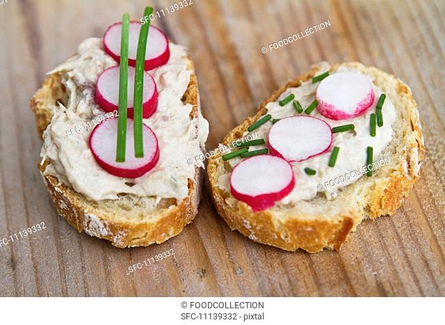Bread topped with a spread, radishes and chives
