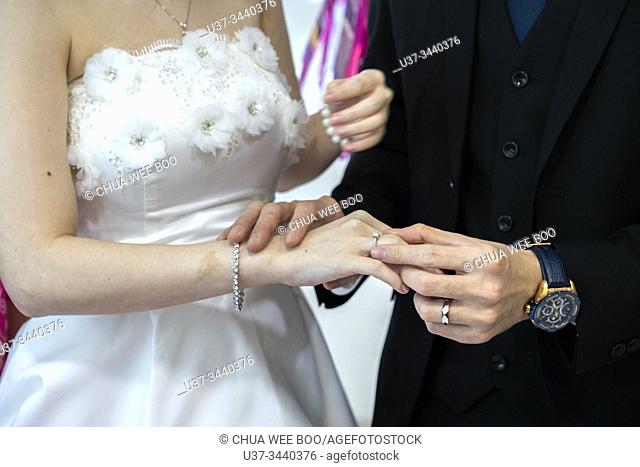 Exchange wedding rings during marriage registration in Sarawak Chai's Clan Association, Kuching, Sarawak, Malaysia