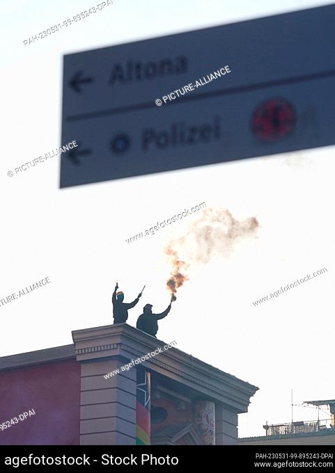 31 May 2023, Hamburg: Two men set off fireworks on the roof of the Rote Flora during a demonstration against the sentencing of suspected left-wing extremist...
