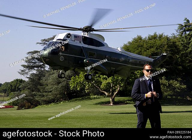 Marine One, carrying US President Joe Biden and First Lady Jill Biden, lands behind a member of the United States Secret Service on the South Lawn of the White...