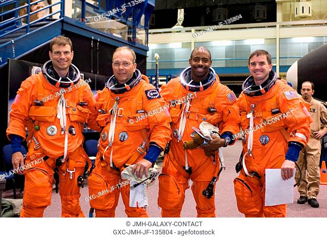 Attired in training versions of their shuttle launch and entry suits, astronauts Stanley G. Love (left), European Space Agency's (ESA) Hans Schlegel, Leland D