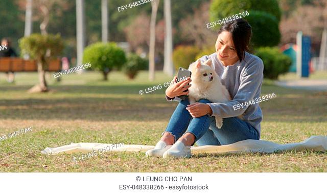 Woman taking selfie by mobile phone with her dog