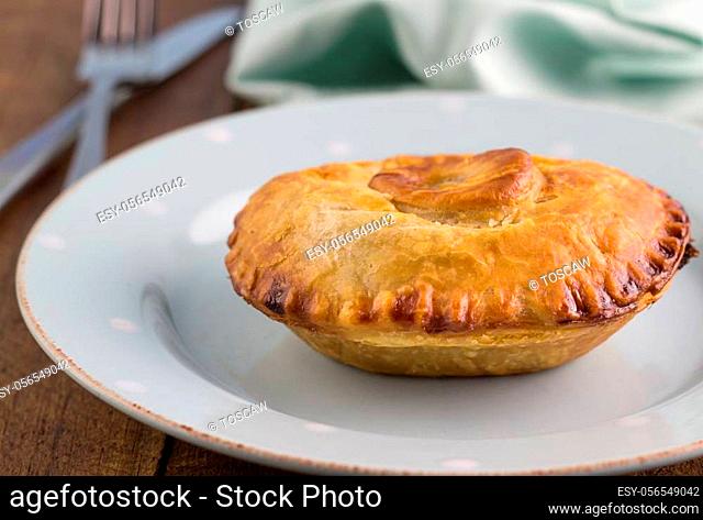 Steak meat pie with gravy - Beef pie in puff pastry close up on plate - Food background
