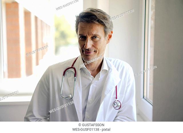 Doctor standing in hospital with stethoscope around neck, portrait