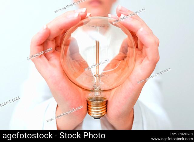 Lady Holding Lamp With Formal Outfit Presenting New Ideas For Project, Business Woman Showing Bulb With Two Hands Exhibiting New Technologies