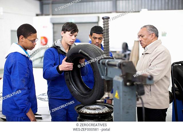 Instructor and trainees in repair garage