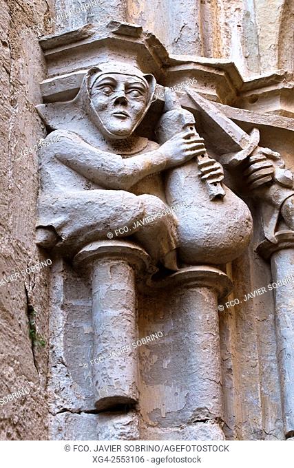 Musician and soldier carved on capital by master mason Reinard de Fonoll, East gallery of 14th century Gothic cloister, Cistercian monastery of Santes Creus