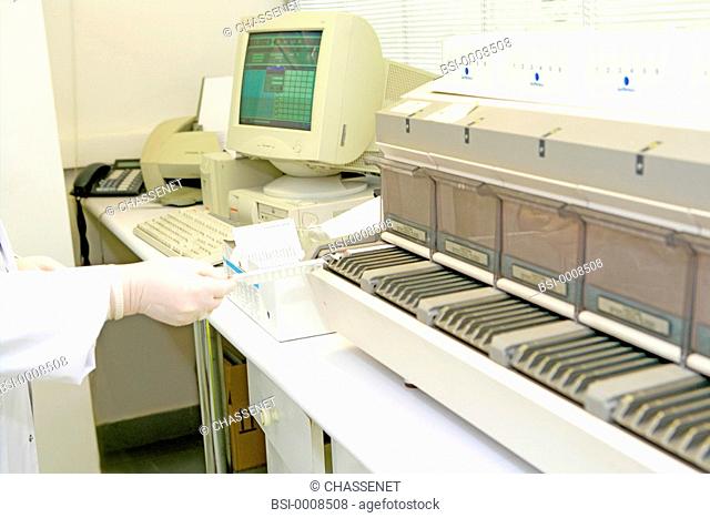Photo essay from laboratory. Multiparametric immunoanalysis automated analyzer VIDAS BioMerieux. The technician is inserting a strip of samples in the device
