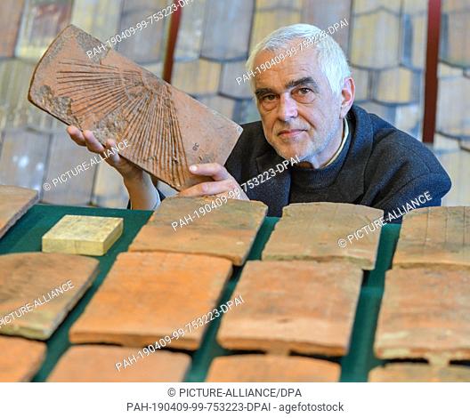 08 April 2019, Brandenburg, Altranft: Peter Herbert, collection manager of the Oderbruch-Museum Altranft (OMA), shows in the new exhibition historical roof...