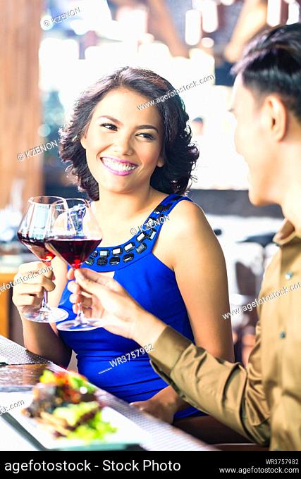 Asian Couple toasting with red wine