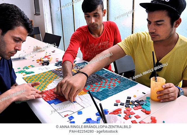 The refugees Kamal Ahmad (r) and Ameer Nawaz (l) from Pakistan, and Matiullah Hussainzai from Afghanistan are making a mosiac together in the backyard of a...