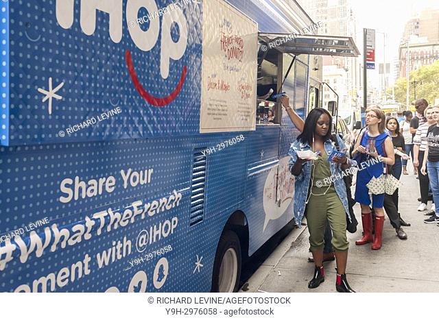 Hungry foodies line up at an IHOP branded food truck in the Flatiron neighborhood of New York for free samples of their newest offering