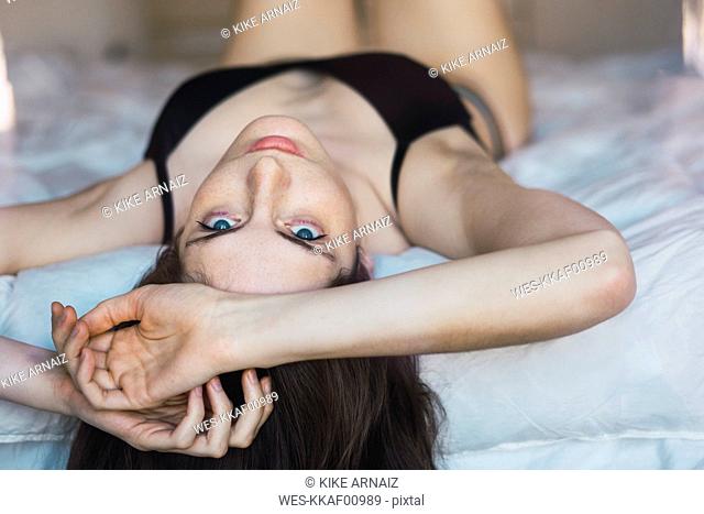 Young woman in underwear lying on bed