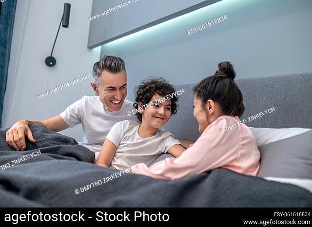 Happy family. A happy family in bed together looking peaceful